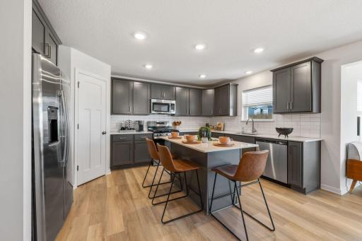 Introducing our Kingston Floorplan in our OriGen Series! Sleek, bright, and inviting - this modern kitchen is perfect for quick bites or lively gatherings. (Picture of model home, actual colors and materials may vary in actual home.)