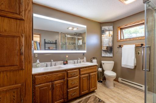 Private primary bathroom with two sinks, linen storage and access to the laundry room/closet.