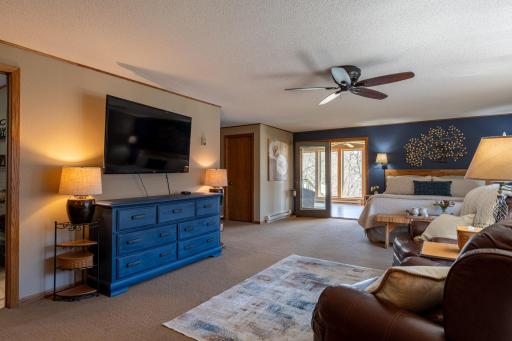 The upper level primary suite and an amazing space featuring a tv area, private bathroom, walk-in closet, laundry room and sunroom.