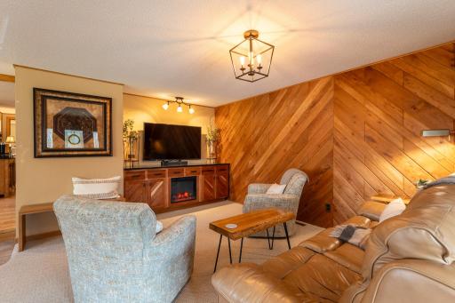 In the living room, the custom cherry tongue in groove 3/4' thick paneling creates a warm ambiance. The built-in custom cherry cabinet with granite top features an electric fireplace which provides a warm glow and heat.