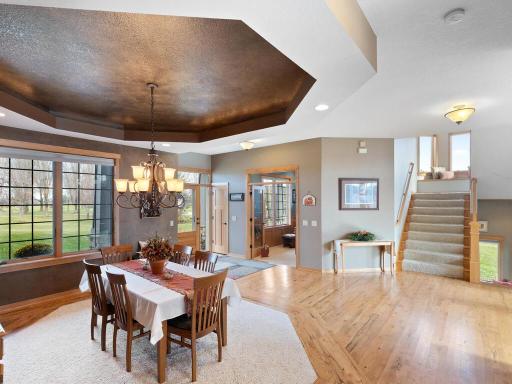 Wide angle view of the foyer, dining room, office, and staircases up and down...both with bright windows.