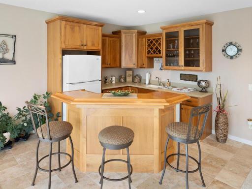 Fabulous wet bar offers a full size refrigerator and great cabinet + wine storage.
