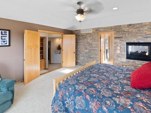Another angle from the primary suite showcasing the double entry doors, special features in the hall and the gas fireplace as it relates to the primary bath.