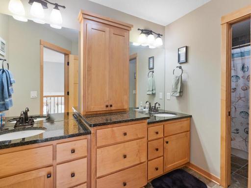 Full upper hall bath offers double sinks, linen cabinet, tile floors, and private shower/water closet.