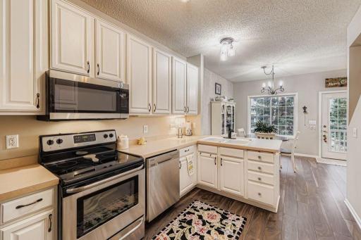 Bright kitchen with stainless appliances, white woodwork and updated lighting.