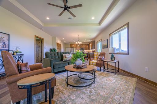 The great room boasts an elegant tray vault ceiling and a striking corner gas fireplace framed by beautiful stonework.