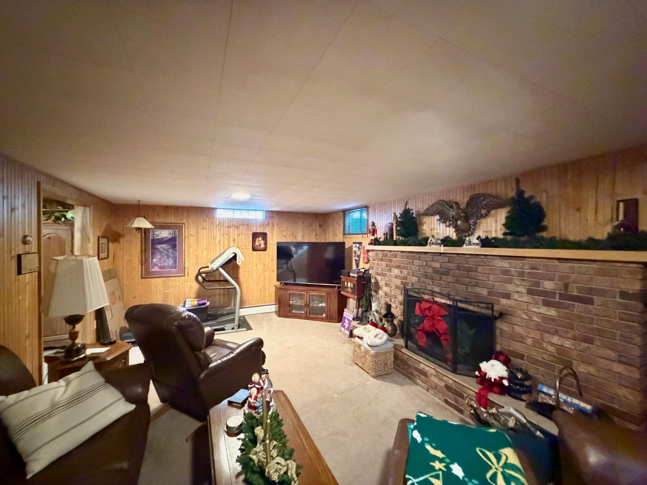 Basement family room with wood fireplacee.
