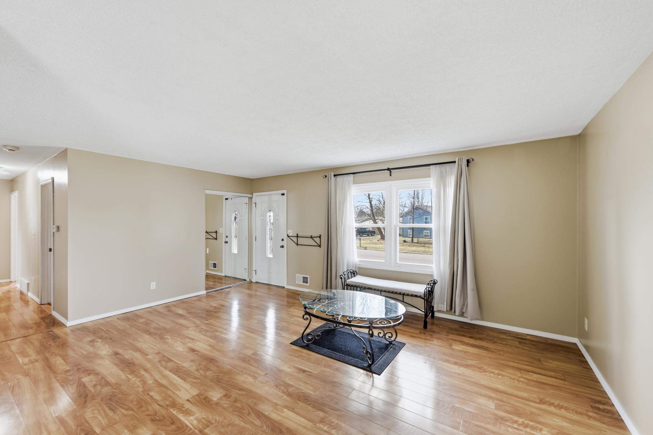 A bright and airy living room boasts large windows that flood the space with natural light, perfect for relaxing or entertaining.