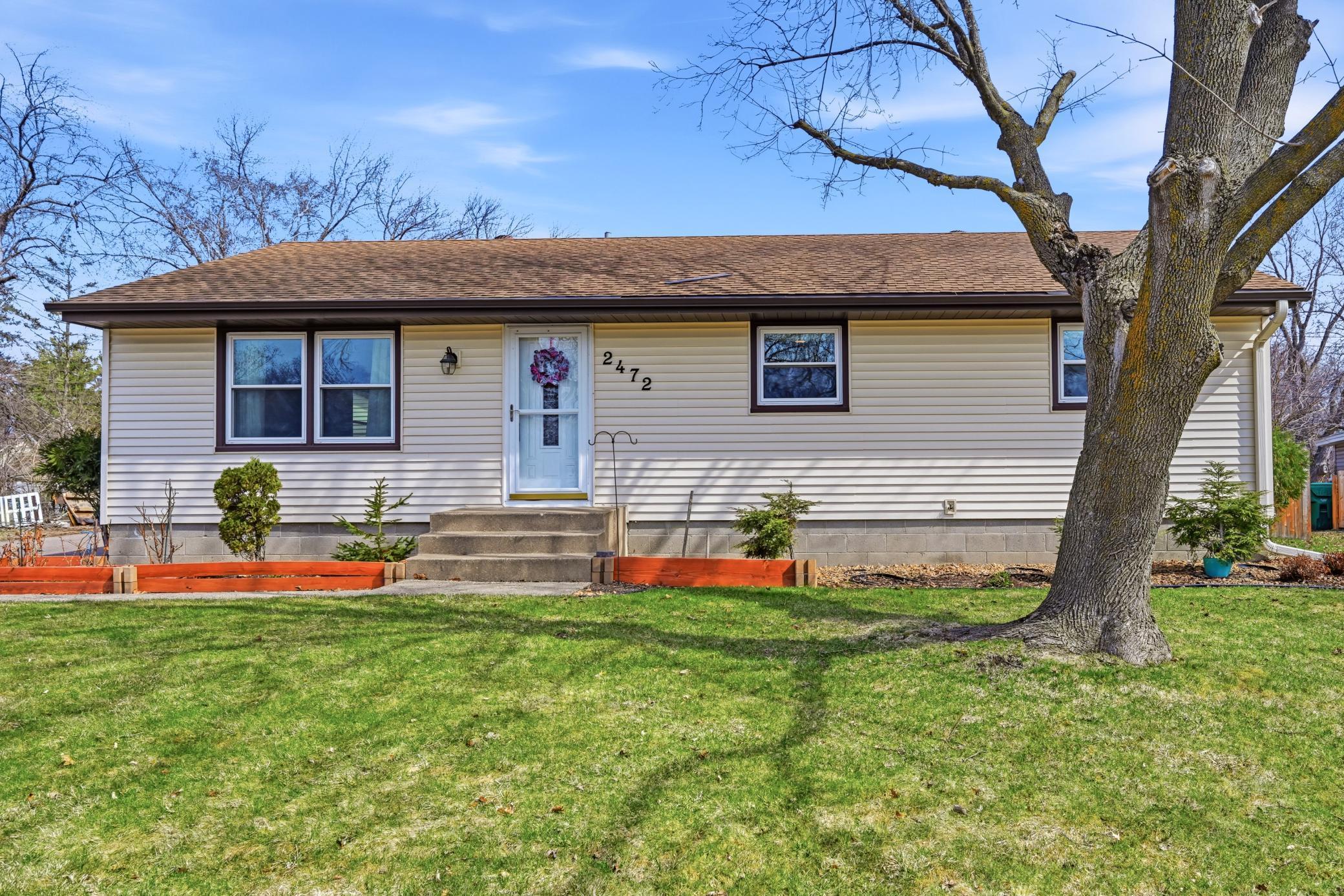 Welcome home! This charming ranch-style home features a clean, neutral siding and a welcoming front entryway with classic concrete steps.