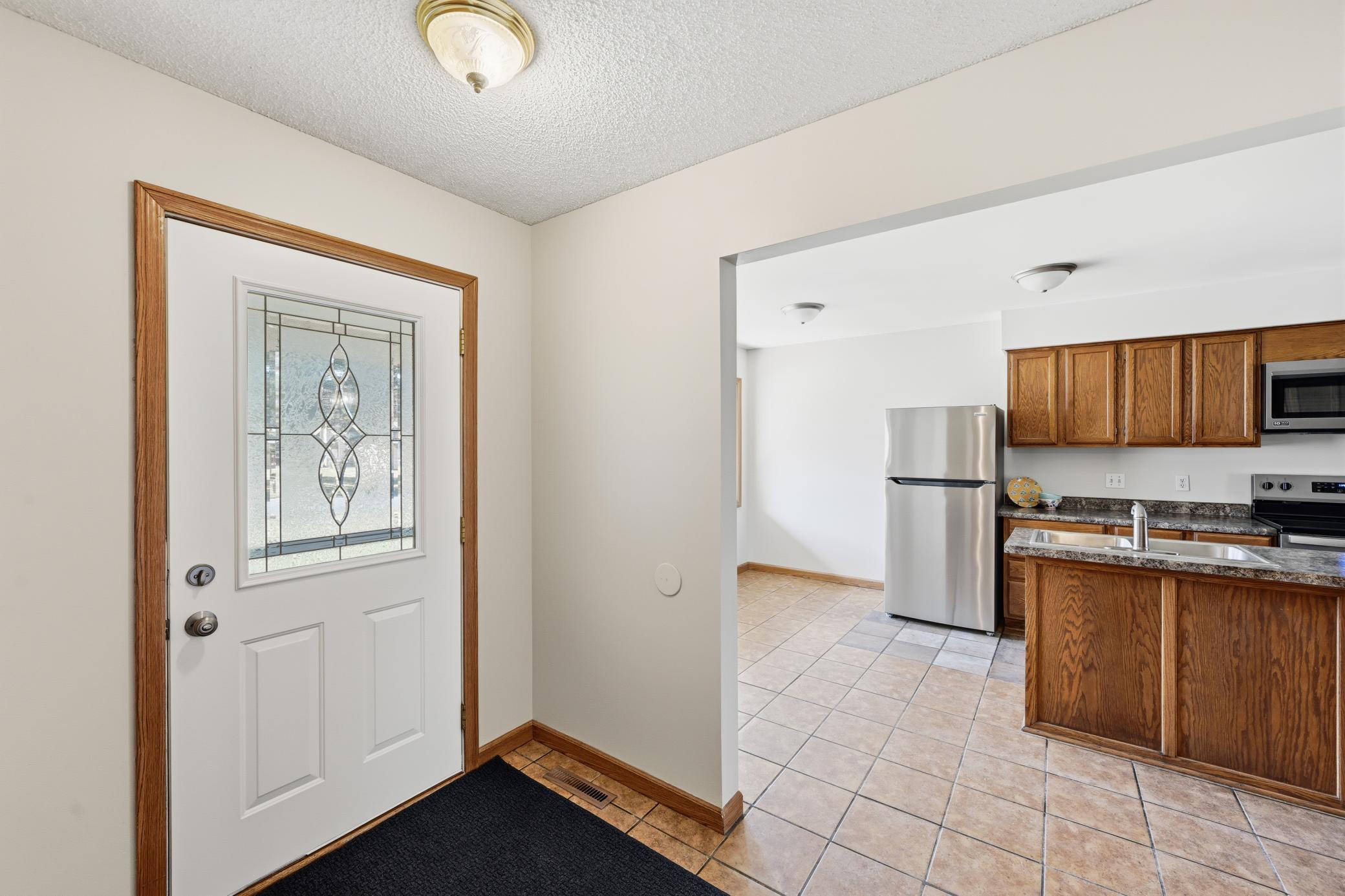 A bright and functional entryway leads into a spacious, open main level with new carpet throughout.
