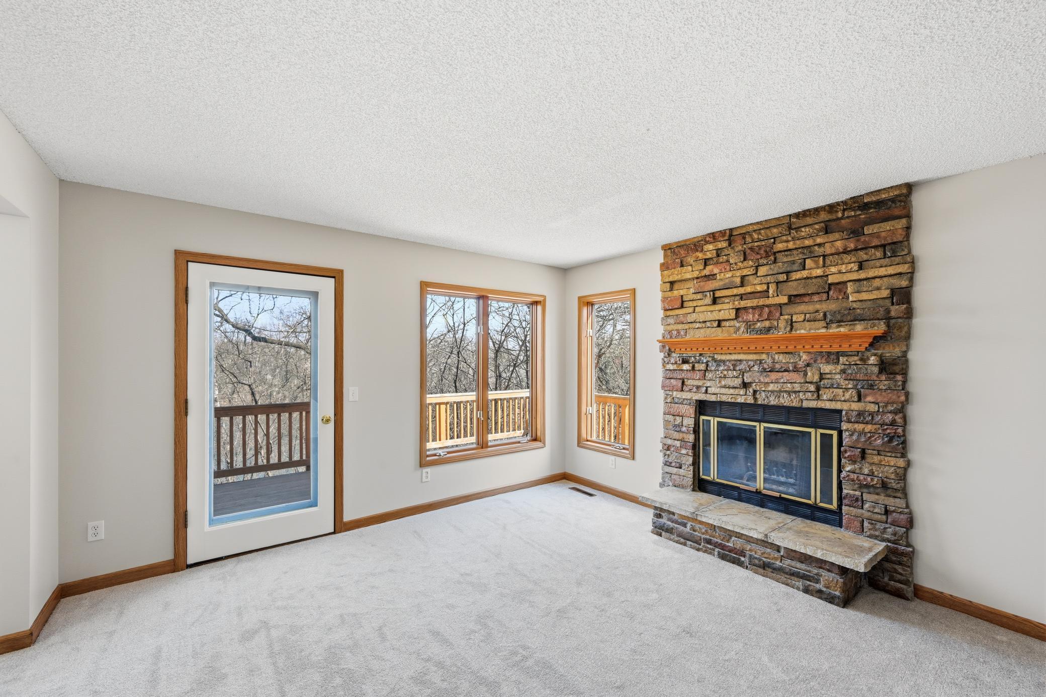 Sun-filled living room featuring large windows that overlook the private, wooded backyard.