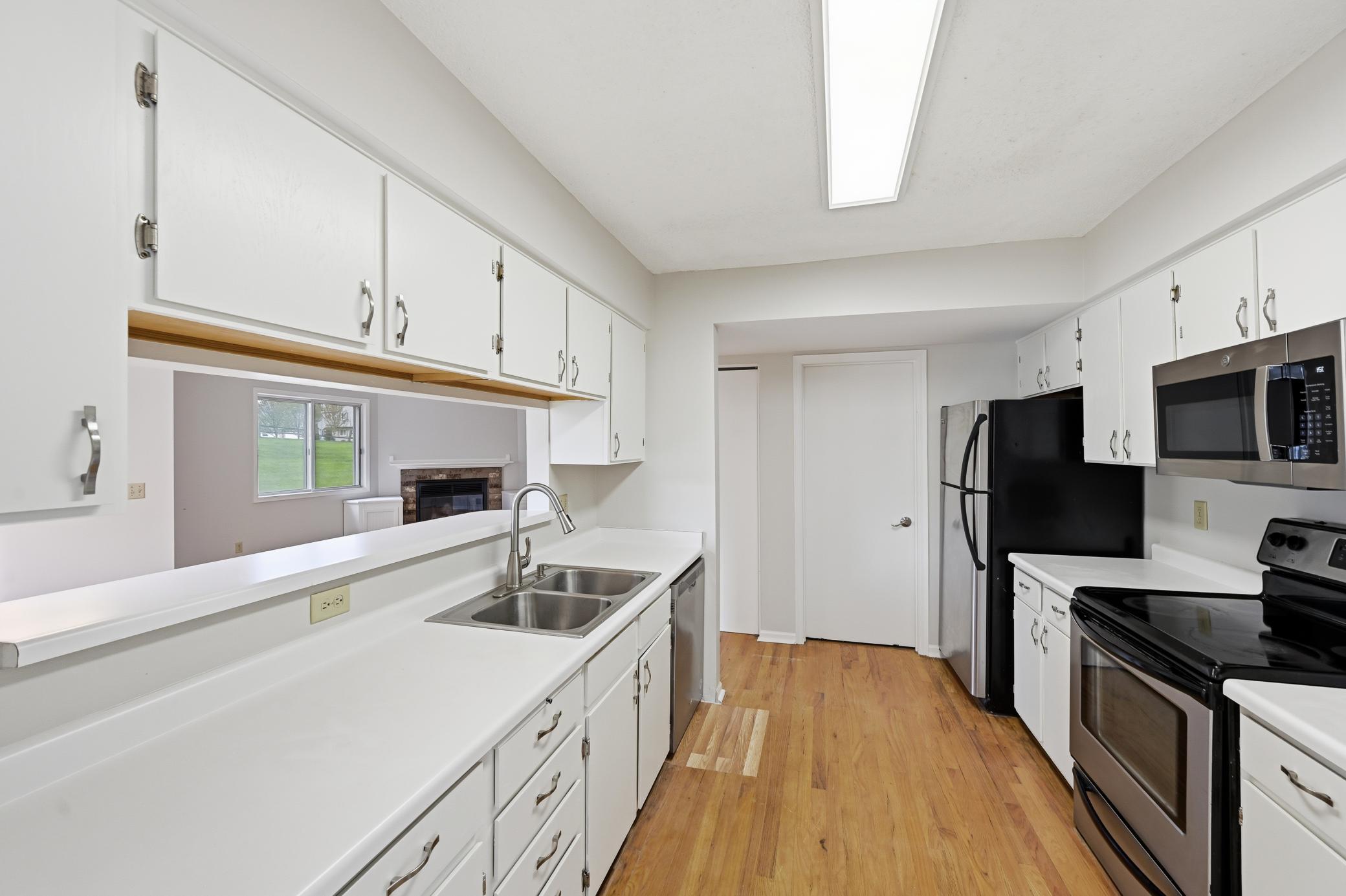 The galley kitchen which has stainless steel appliances and white cabinets offers the perfect space for preparing delicious meals.