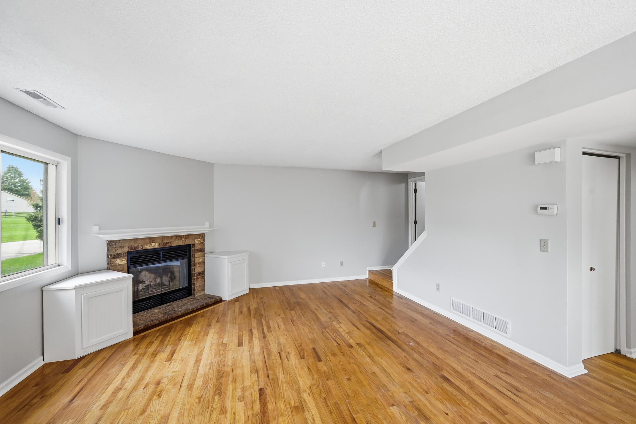 A wood burning fireplace adds charm to the living room.