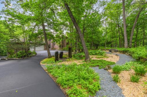Entering the driveway, youâre greeted by elegant Basalt stone pillars, mature trees, thoughtfully designed walking paths, and lush landscaping that seamlessly blends with the natural beauty of the St. Croix River bluffs.