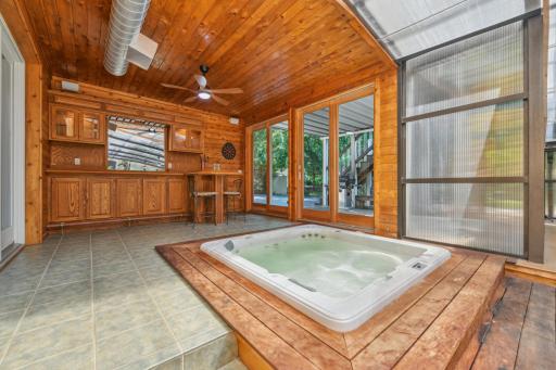 Step through the patio door into a unique recreation space featuring a tongue-and-groove ceiling, wet bar with built-in keg tap, and a hot tubâan ideal setting for entertaining guests.