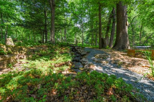 Another serene water feature, with water gently flowing down a smooth slope and collecting in a tranquil pool beside the patio.