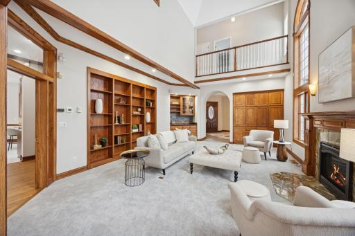 The fireplace, framed in Brazilian marble, serves as an elegant centerpiece accented by the mantel and sconce lighting, while the built-in bookshelves offer the perfect space to showcase your favorite books and curated dÃ©cor.