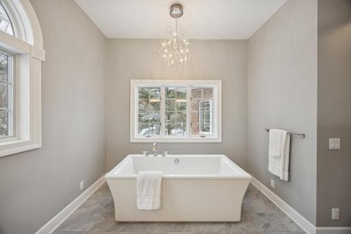 After a long day, unwind in the free-standing soaking tub, beautifully illuminated by an elegant chandelier.