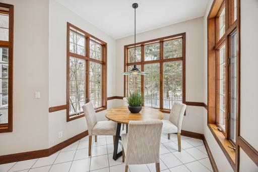 Start your day in this bright, airy breakfast nook, where large wood-framed windows fill the space with light and serene views of the surrounding trees. Open the windows and listen to the gentle sound of water cascading from the water feature.