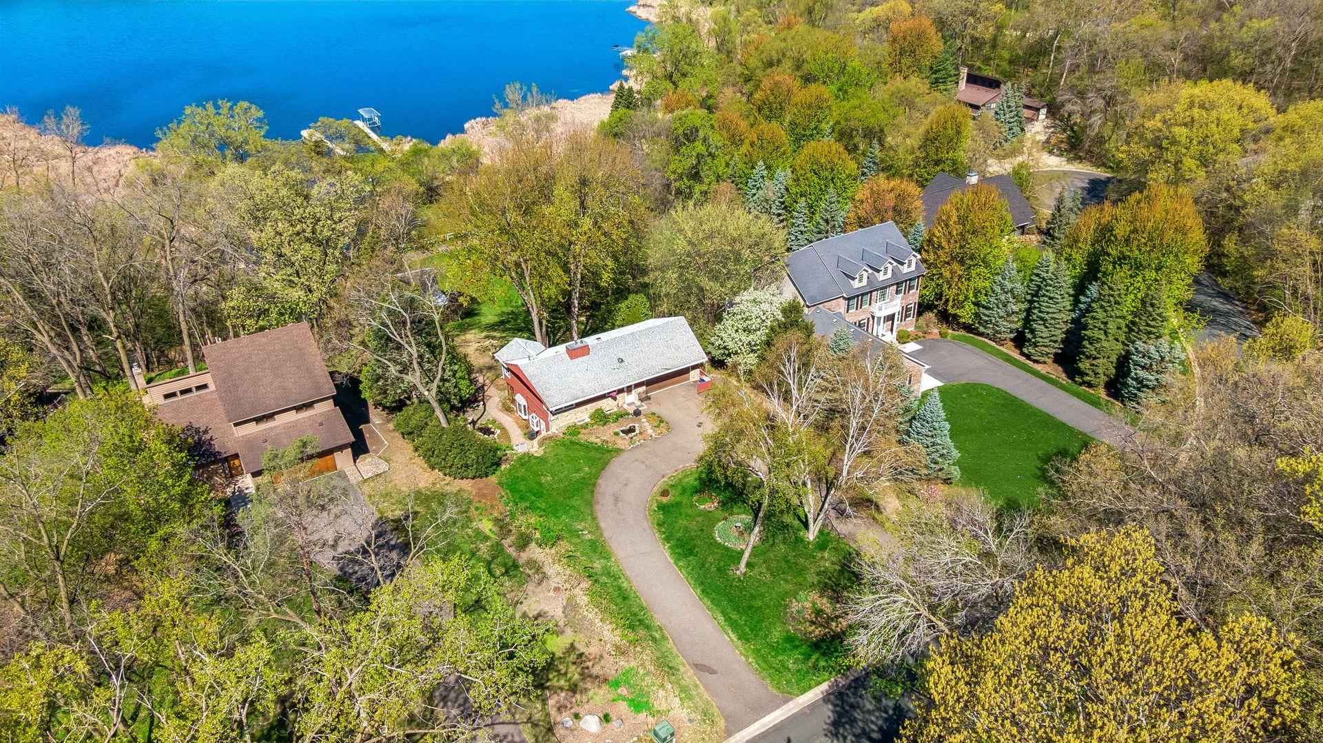 An airial shot of the home to the lake and driveway.