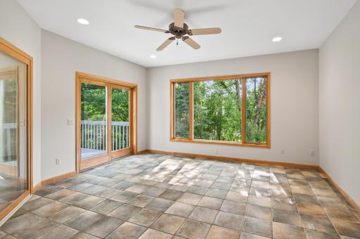 Sun Room walks out to deck and overlooks serene backyard setting