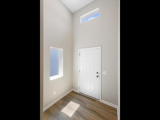 Photo of a different home with similar plan & finishes. Foyer features roughly a 13' ceiling and windows. Photo may not depict actual plan & finishes.