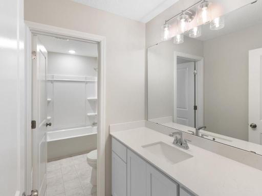 Hall Bathroom. Photo taken of another home with similar plan and finishes. Photos and renderings may not depict actual plan, materials, & finishes may vary. All measurements are approximate.