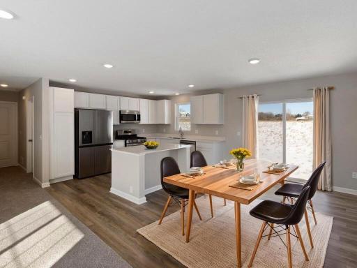 Kitchen and Dining Room, Virtually Staged. Photo is taken of another home with similar plan and finishes.
