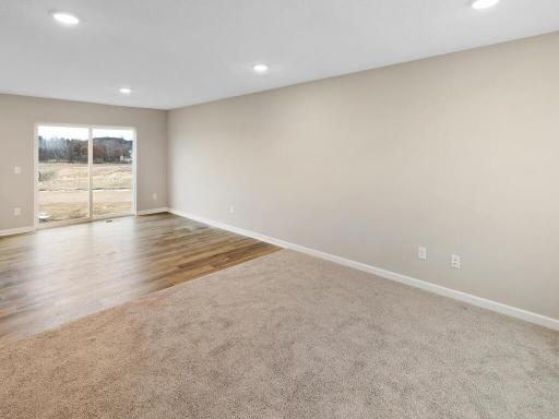 Living Room and Dining Room. Photo is taken of another home with similar plan and finishes.