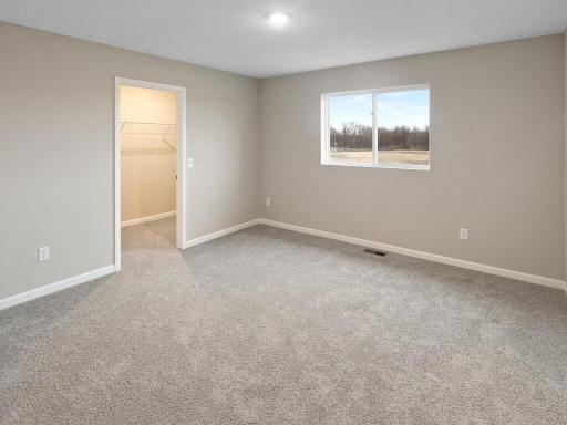Primary Bedroom. Photo is taken of another home with similar plan and finishes.
