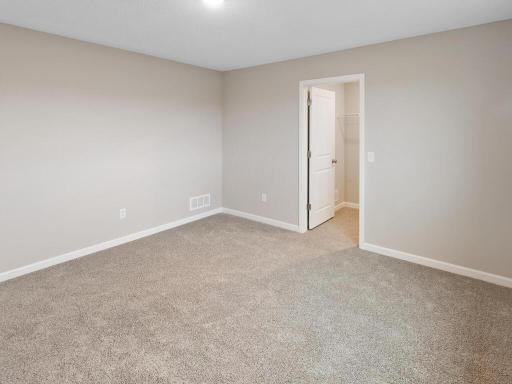 Primary Bedroom. Photo is taken of another home with similar plan and finishes.