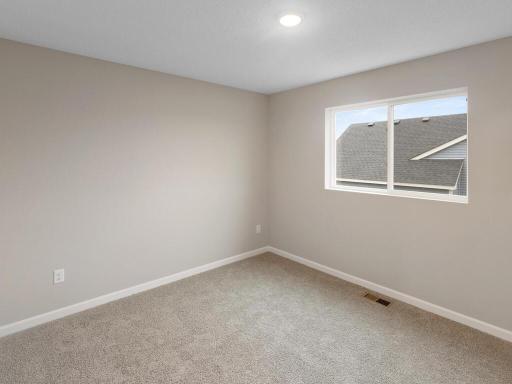Bedroom 2. Photo is taken of another home with similar plan and finishes.