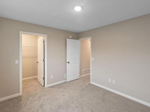 Bedroom 2, Includes Walk In Closet. Photo is taken of another home with similar plan and finishes.