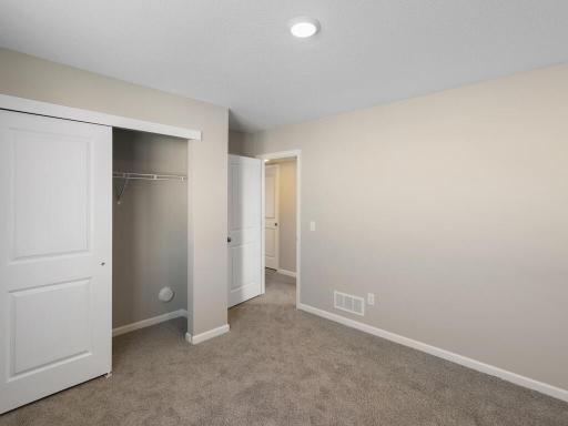Lower Level Finished Bedroom 3. Photo is taken of another home with similar plan and finishes.