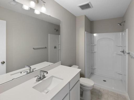 Lower Level Finished Bathroom. Photo is taken of another home with similar plan and finishes.