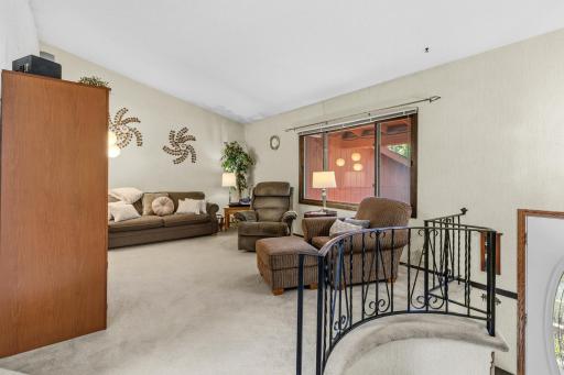The living room features vaulted ceilings with a unique curved stairway leading up from the front door.
