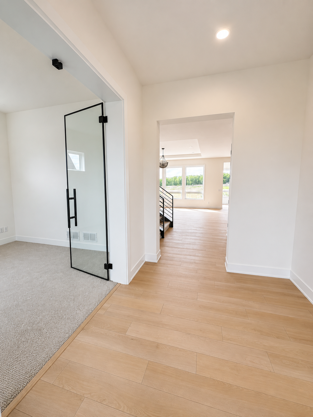 Welcoming entry hallway with wide-plank luxury flooring, clean architectural lines, and an open sightline into the heart of the home.