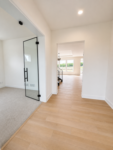 Welcoming entry hallway with wide-plank luxury flooring, clean architectural lines, and an open sightline into the heart of the home.