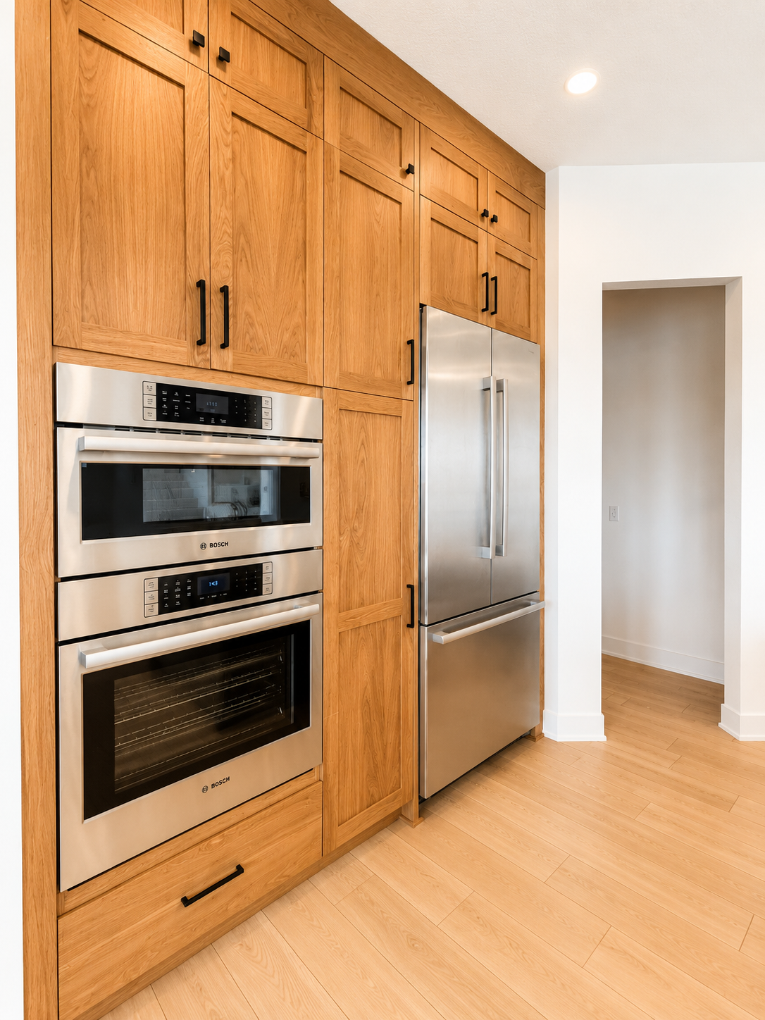 Gourmet kitchen featuring ceiling-height custom cabinetry, premium stainless steel appliances, quartz countertops, and a spacious walk-in pantry.