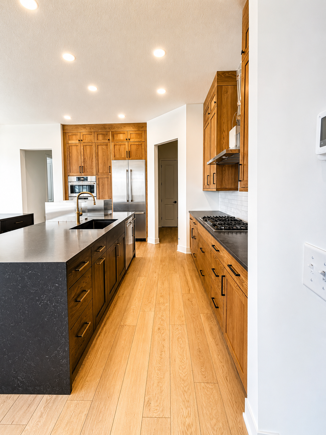 Gourmet kitchen featuring ceiling-height custom cabinetry, premium stainless steel appliances, quartz countertops, and a spacious walk-in pantry.