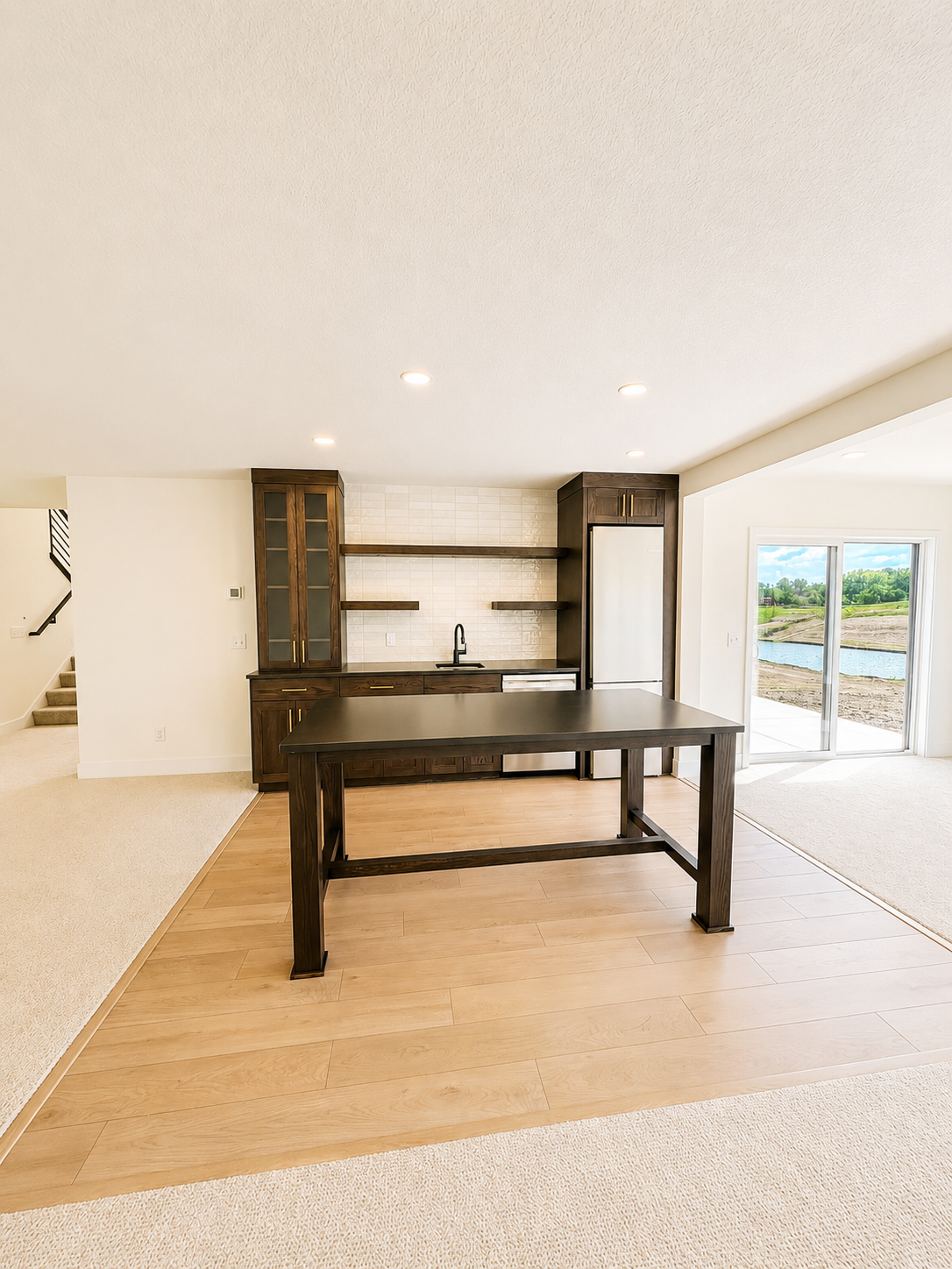 Elegant lower-level wet bar with custom cabinetry, floating shelves, beverage refrigerator, and quartz countertops—ideal for entertaining.
