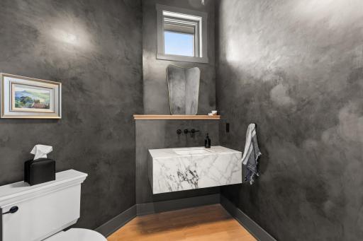 Custom marble floating vanity and Venetian plaster walls create a beautiful main floor powder room.
