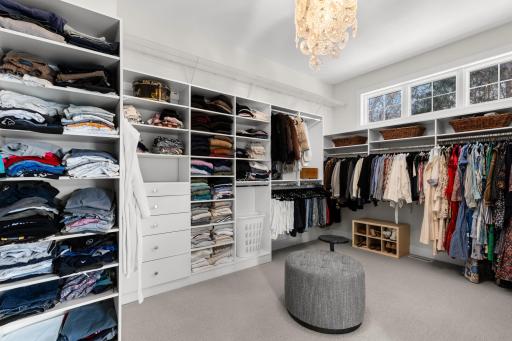 Generous primary closet with custom built-in shelving and drawers.