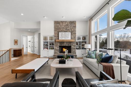 Living room with stone fireplace - leading to main floor office and open to lower level stairs.