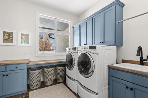 Generously sized laundry room with folding space and cabinet storage.