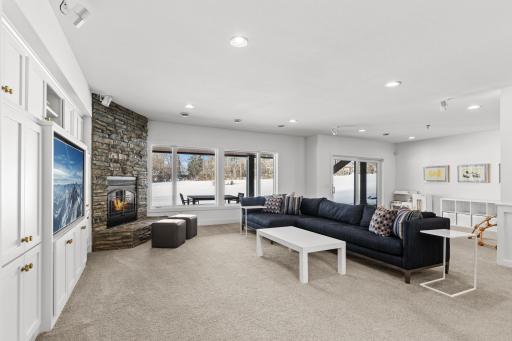 Lower level walkout family room with fireplace, broad views, and back yard access.