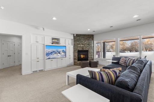 Lower level family/ media room with fireplace, enameled cabinetry and storage spaces.