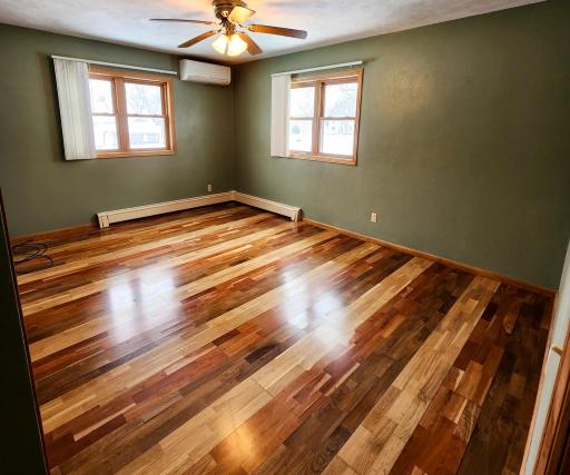 Main Floor Primary Bedroom with hardwood floors, mini split ac and tip in to clean double hung windows.jpg