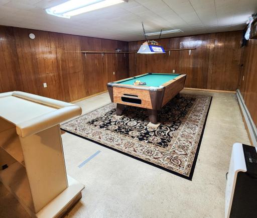 The basement billiards room is already set up for entertaining. A wood burning fireplace rounds out this space. Pool table, beer signs and portable bar will stay with the house..jpg
