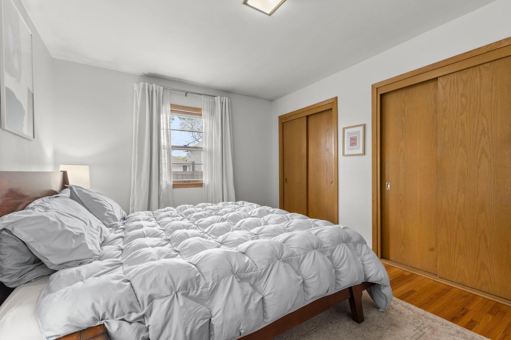 Dual closets with refinished wood flooring. Freshly painted bedroom